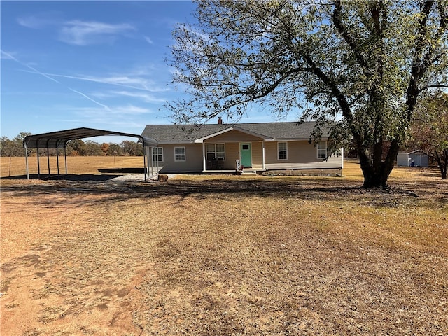 back of property featuring covered porch, a carport, and a lawn