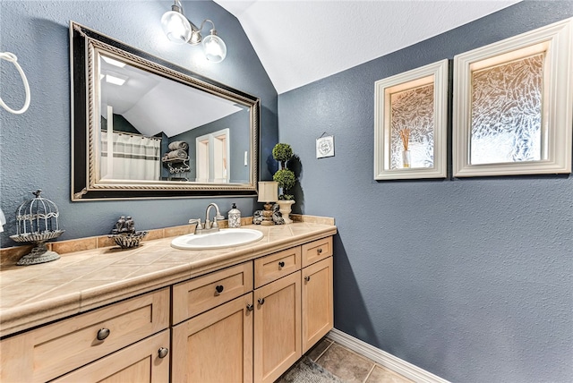 bathroom featuring vanity, tile patterned floors, and lofted ceiling