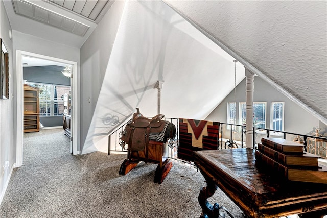 interior space featuring lofted ceiling, carpet floors, and a textured ceiling