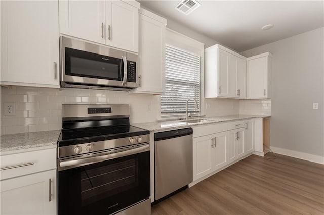 kitchen featuring appliances with stainless steel finishes, white cabinetry, and sink