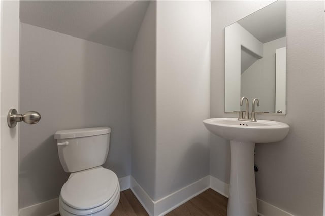 bathroom featuring hardwood / wood-style floors, toilet, and vaulted ceiling