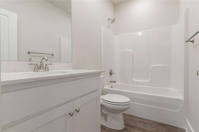 full bathroom featuring hardwood / wood-style floors, vanity, toilet, and shower / bathtub combination