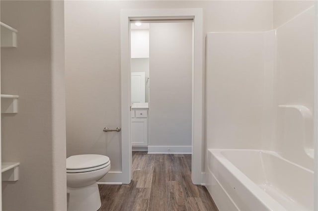 full bathroom with shower / washtub combination, hardwood / wood-style floors, vanity, and toilet