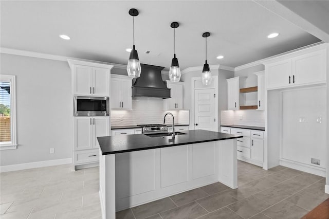 kitchen with stainless steel microwave, sink, premium range hood, pendant lighting, and white cabinets