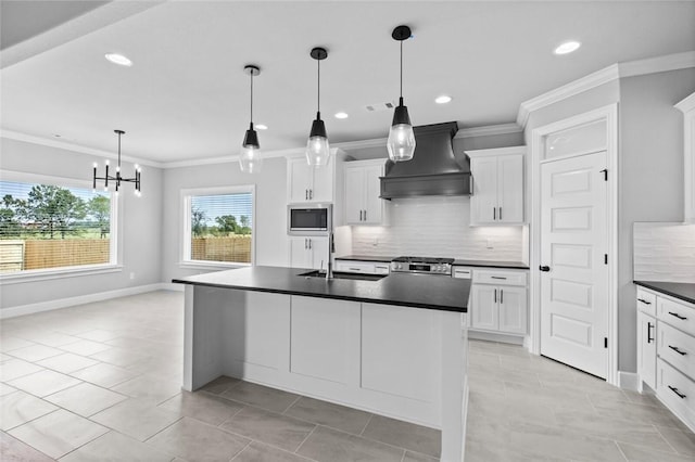 kitchen featuring custom exhaust hood, sink, appliances with stainless steel finishes, decorative light fixtures, and white cabinetry