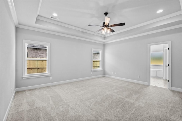 carpeted empty room with a raised ceiling, ceiling fan, and ornamental molding