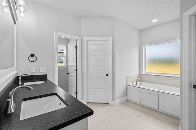 bathroom featuring a tub, tile patterned flooring, and vanity