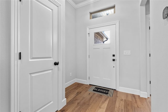 entryway with light wood-type flooring and crown molding