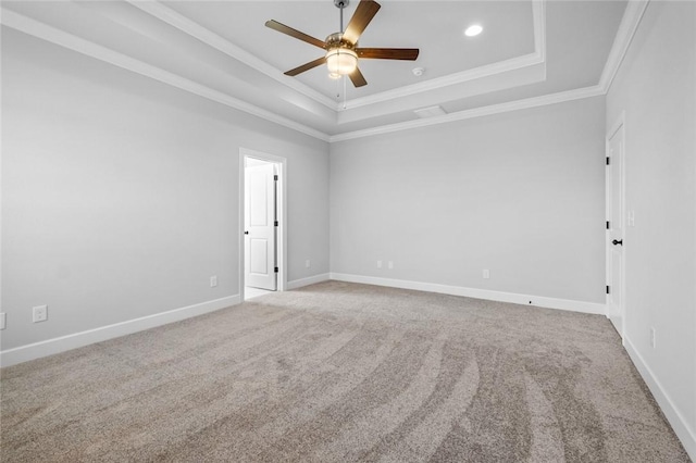 carpeted spare room featuring ceiling fan, ornamental molding, and a tray ceiling