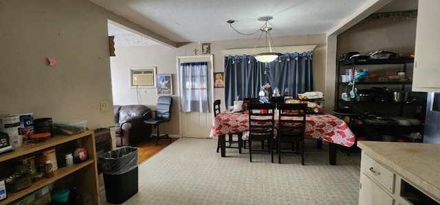 dining room featuring beamed ceiling, a wall mounted AC, and a textured ceiling