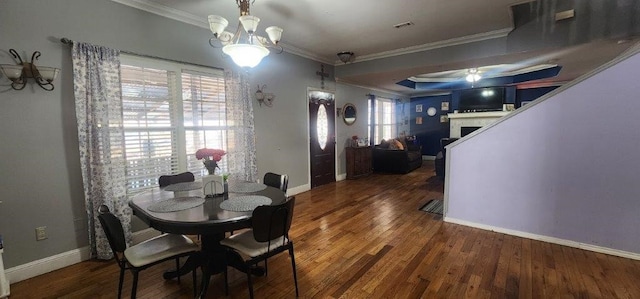 dining space featuring dark wood-type flooring, ornamental molding, and a chandelier