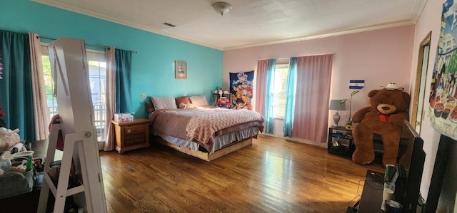 bedroom featuring ornamental molding and wood-type flooring