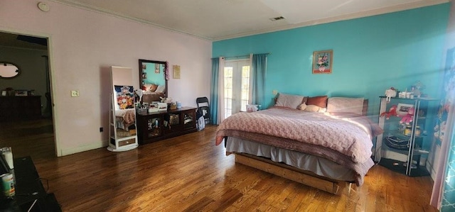 bedroom with ornamental molding and dark hardwood / wood-style floors