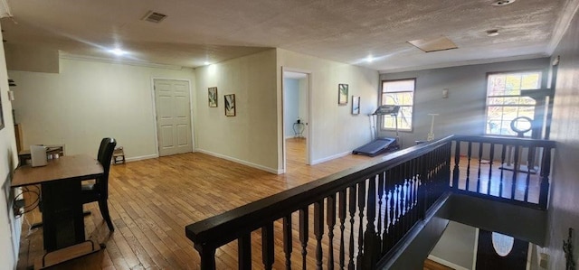 hallway with wood-type flooring and a textured ceiling