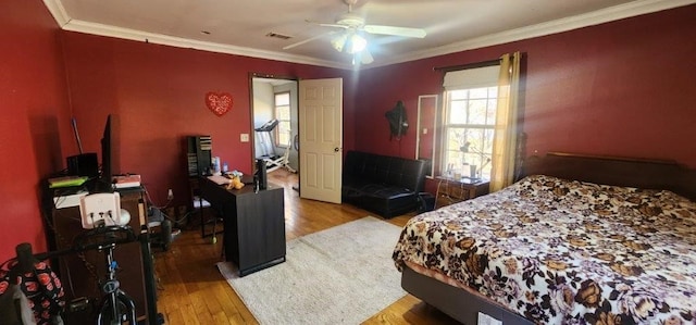 bedroom with crown molding, ceiling fan, and light hardwood / wood-style floors