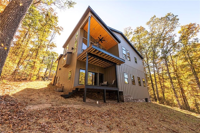 back of property featuring a balcony and ceiling fan