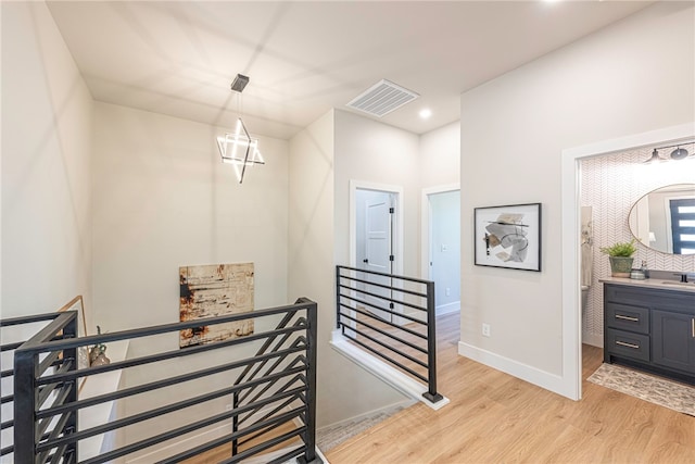 staircase featuring sink and hardwood / wood-style floors