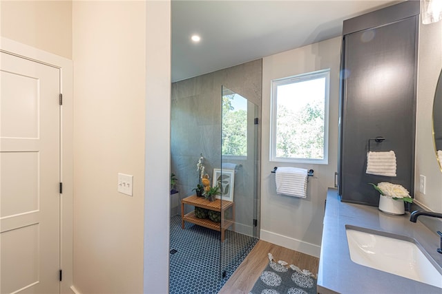 bathroom featuring hardwood / wood-style flooring, vanity, and walk in shower