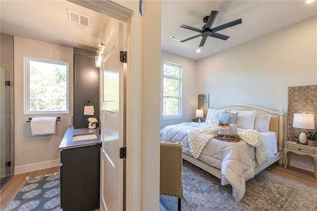 bedroom featuring sink, dark hardwood / wood-style floors, and ceiling fan