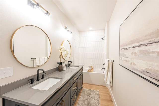 bathroom with vanity, hardwood / wood-style floors, and a tub