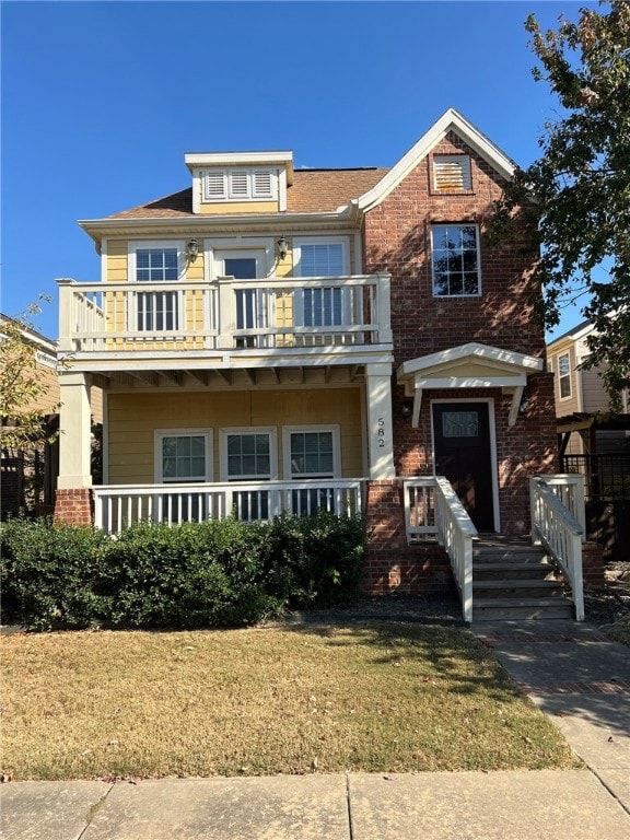 view of front of property featuring a front yard and a balcony