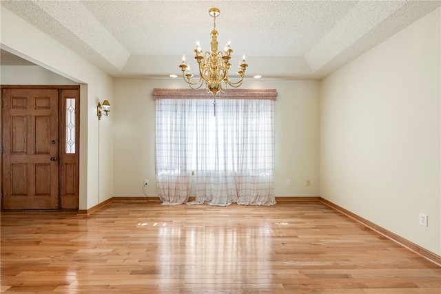 foyer featuring a healthy amount of sunlight, light hardwood / wood-style floors, and a textured ceiling