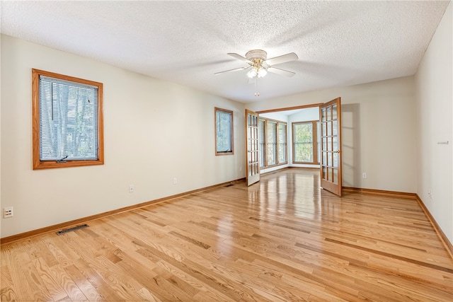 unfurnished room featuring a textured ceiling, light wood-type flooring, and ceiling fan