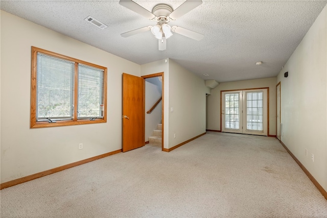 carpeted spare room with ceiling fan and a textured ceiling