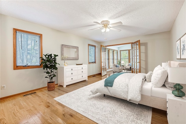 bedroom featuring a textured ceiling, light hardwood / wood-style flooring, and ceiling fan