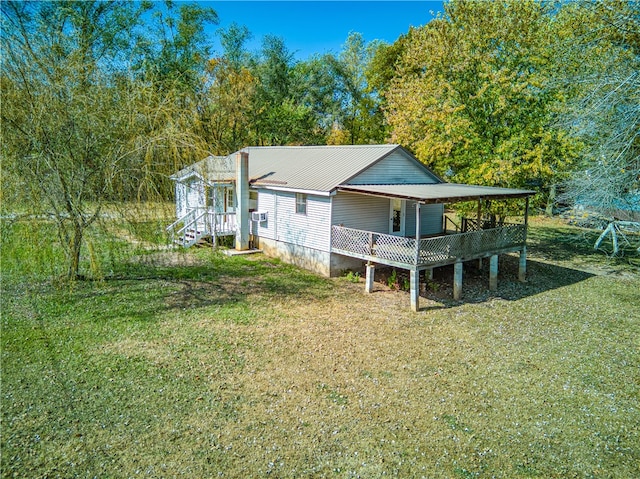 rear view of house featuring a deck and a yard