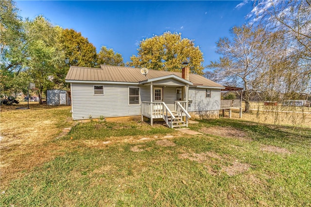 back of property featuring a shed and a lawn