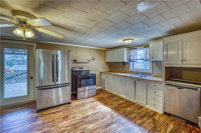 kitchen with appliances with stainless steel finishes, white cabinets, sink, and light wood-type flooring