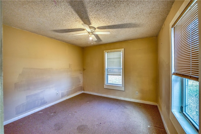 spare room with ceiling fan, a textured ceiling, and plenty of natural light