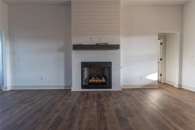 unfurnished living room with dark hardwood / wood-style flooring and a fireplace