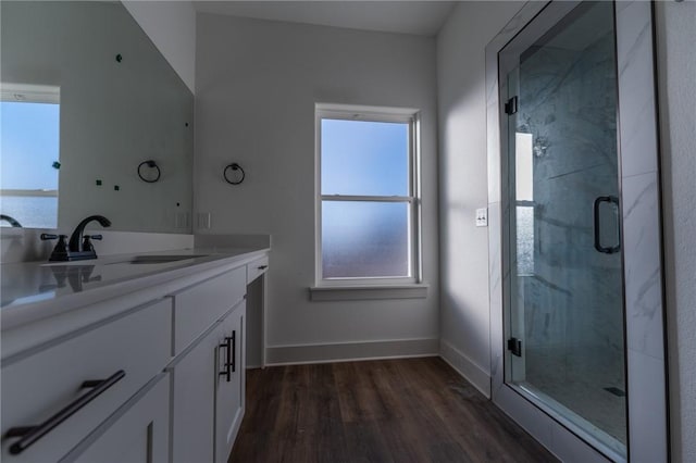 bathroom with a water view, hardwood / wood-style floors, vanity, and an enclosed shower