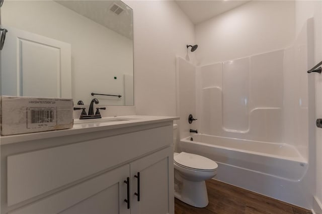 full bathroom with hardwood / wood-style floors, vanity,  shower combination, and toilet