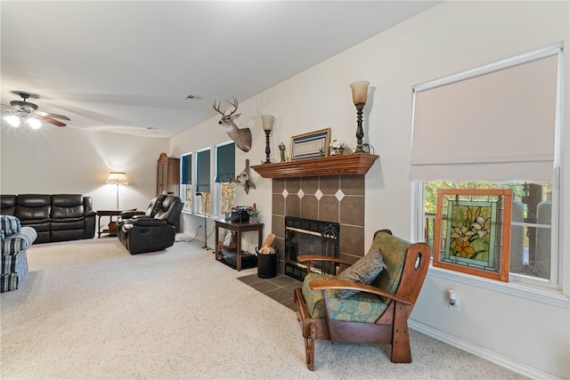 carpeted living room with a tile fireplace, a healthy amount of sunlight, and ceiling fan