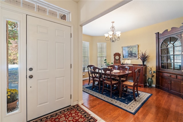 dining room with a healthy amount of sunlight, a notable chandelier, and dark hardwood / wood-style flooring