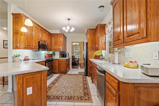 kitchen with light tile patterned floors, sink, appliances with stainless steel finishes, an inviting chandelier, and hanging light fixtures