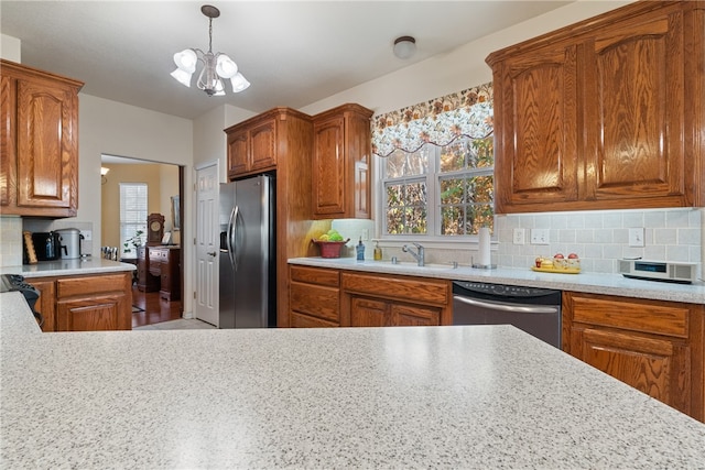 kitchen featuring appliances with stainless steel finishes, sink, pendant lighting, and decorative backsplash