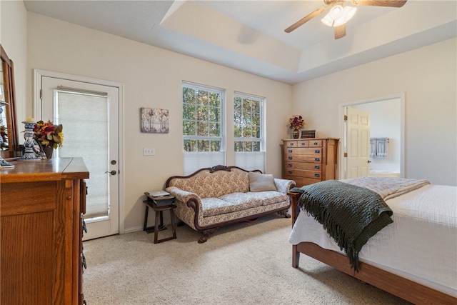 carpeted bedroom with ceiling fan, connected bathroom, and a raised ceiling