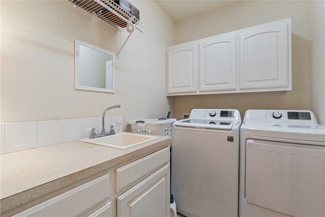 washroom featuring cabinets, washer and clothes dryer, and sink