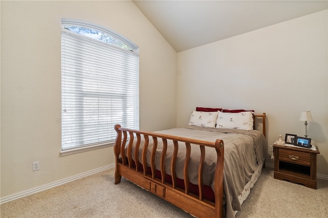 bedroom featuring multiple windows and lofted ceiling