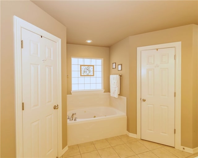 bathroom with a tub to relax in and tile patterned flooring