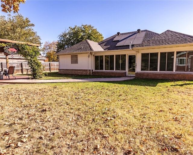 rear view of house with a patio area and a lawn