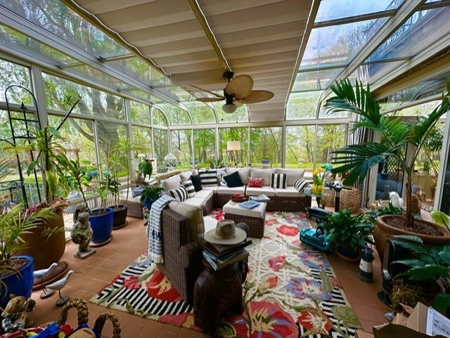 sunroom featuring ceiling fan and beamed ceiling