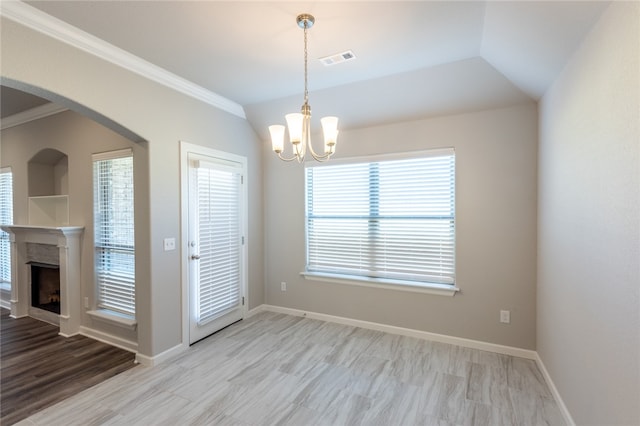 unfurnished dining area featuring lofted ceiling, light hardwood / wood-style flooring, ornamental molding, and an inviting chandelier