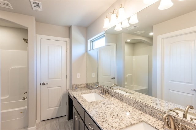 bathroom with vanity and shower / washtub combination