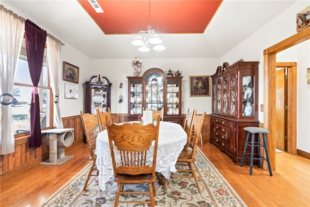 dining space featuring a chandelier, light hardwood / wood-style flooring, and vaulted ceiling