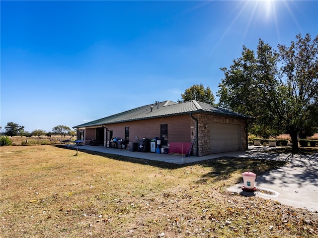 view of side of property with a garage and a lawn